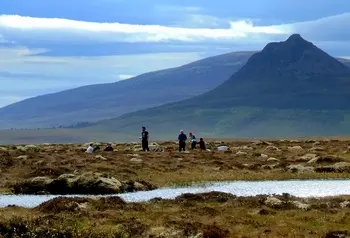People in natural landscape with mountain in distance