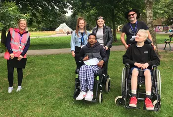 Six people outside. Two people are wheelchair users. 