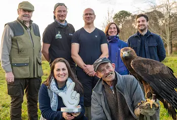 Group of people holding award and an eagle