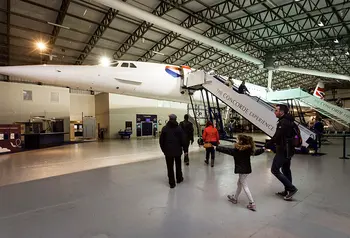 People approaching aeroplane in hangar 