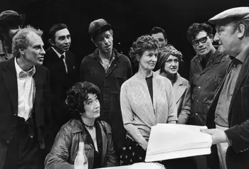 Arthur Berry, wearing a flat cap and holding a script, talks with the cast of one of his plays at the Victoria Theatre, Stoke.