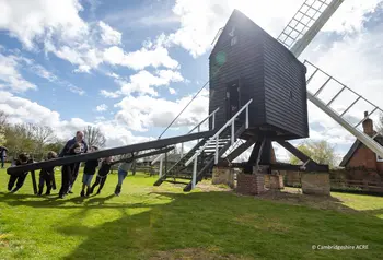 A group of people including children turn Bourn Windmill