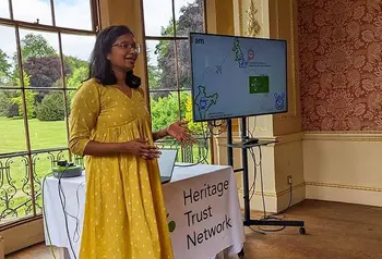 Gopika Jayasree stands beside a digital screen and gives a talk 