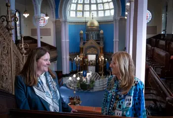 Two people standing on an internal balcony in Glasgow's Garnethill synagogue