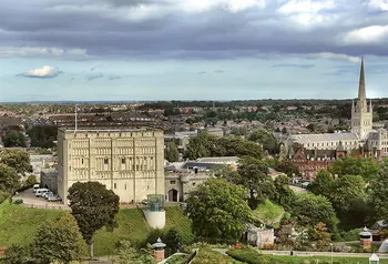 exterior view of a large norman castle in the middle of a city