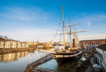 SS Great Britain sits in dock on Bristol waterfront, on a bright and sunny day.