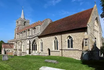 The outside of a stone English parish church with a graveyard in the foreground