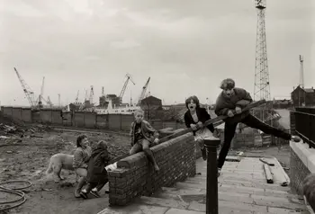 A black and white image of children playing in an industrial area.