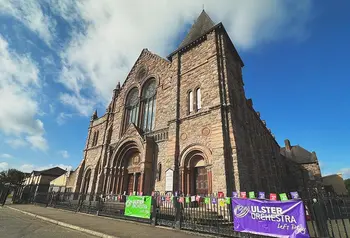 the exterior of a large stone church on a street