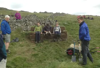 Young people sitting on an outdoor bench made from turf
