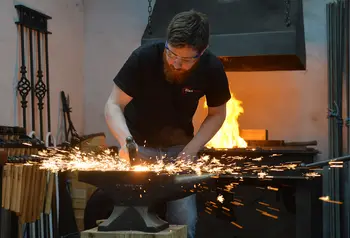 A blacksmith works at an anvil