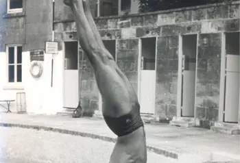 Man doing a handstand by a swimming pool