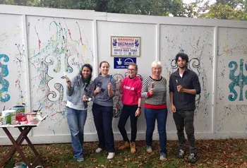 Five young volunteers with paintbrushes