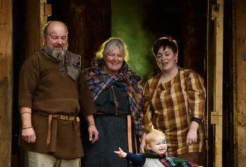 A family group in Iron Age dress in the doorway of the round House