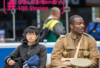 21st century man dressed as First World War soldier sitting next to commuters in a train station  