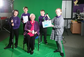 An older woman is interviewed by four children