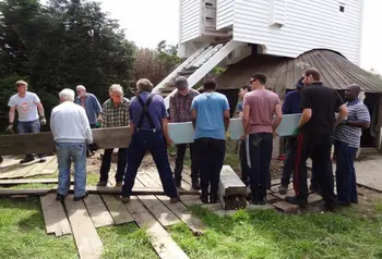 People restore a windmill