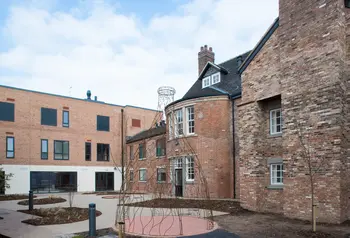 An old two-story brick building surrounds a paved courtyard 