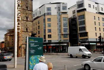 A couple read an information board in Merchant City