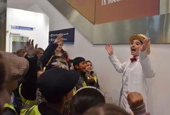 Young actor playing the part of an ice cream seller for visiting school pupils