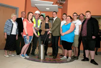 Young people placing their time capsule into the floor of their youth club