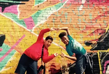Young people pose by graffiti art