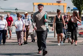 A tour group walking around Belfast's docklands on a sunny day