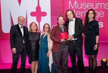 A group of people posing with an award