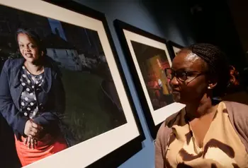 Twimukye Mushaka smiles whilst looking at a portrait of herself on display.