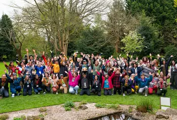 A large group of young people cheering outdoors