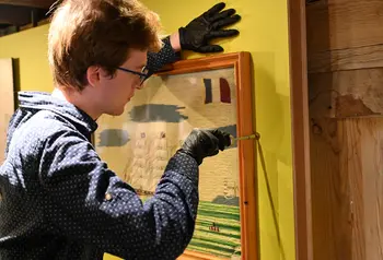 A person installing a exhibit at Poole Museum