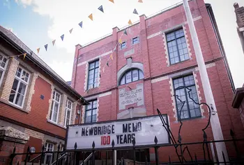 The exterior of a red brick building decorated with bunting and a sign that says "Newbridge Memo 100 years"