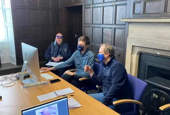 Three people working at computer