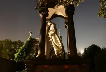 Statue at West Norwood Cemetery lit up at night