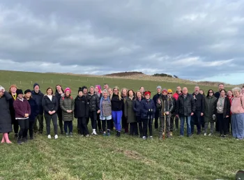 A large group of people stand together outdoors in the newly created nature reserve