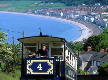 The tram on its way to the summit with a view of a beach below
