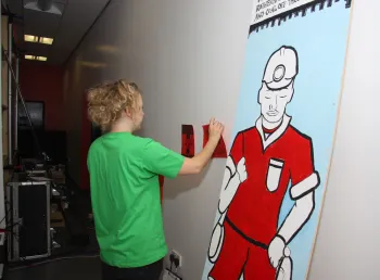 A young person setting up an exhibition for the From Coal to Goal project