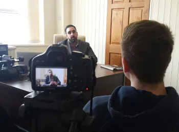 Young volunteer interviewing participant on the subject of their experience of British life