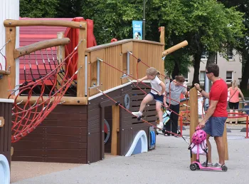Family playing on playpark structures.