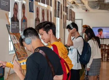 Young people engage in the exhibition and listen to the interviews on a headset