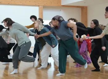 A group of people are in a studio taking part in a movement and dance workshop
