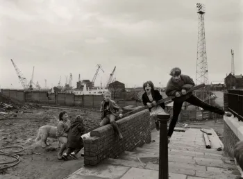 A black and white image of children playing in an industrial area.