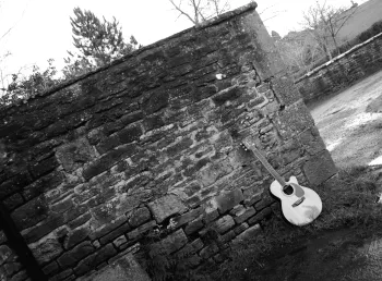 Gitâr Noel Gallagher yn pwyso yn erbyn wal yn Stiwdios Rockfield