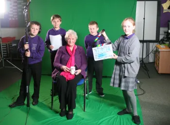 An older woman is interviewed by four children