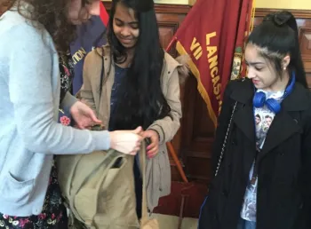 Young people look at army bag
