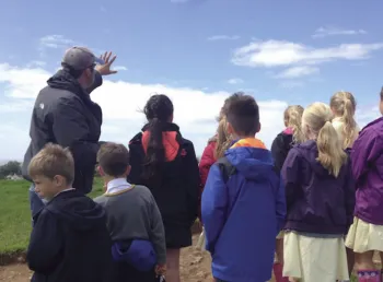 Children listening to a talk about the archaeological site