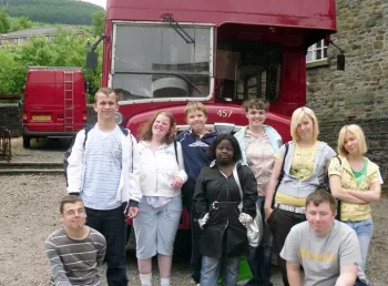 Young people in front of a vintage bus