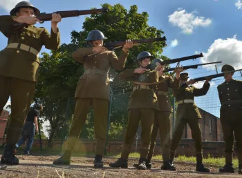 Men line up with guns to execute a soldier for cowardice. A still from ‘After Dawn’, the film created by young people at Central Youth Theatre.