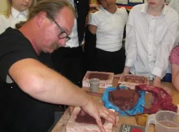 School children watching as poppy plaques are created by an artist