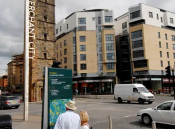 A couple read an information board in Merchant City